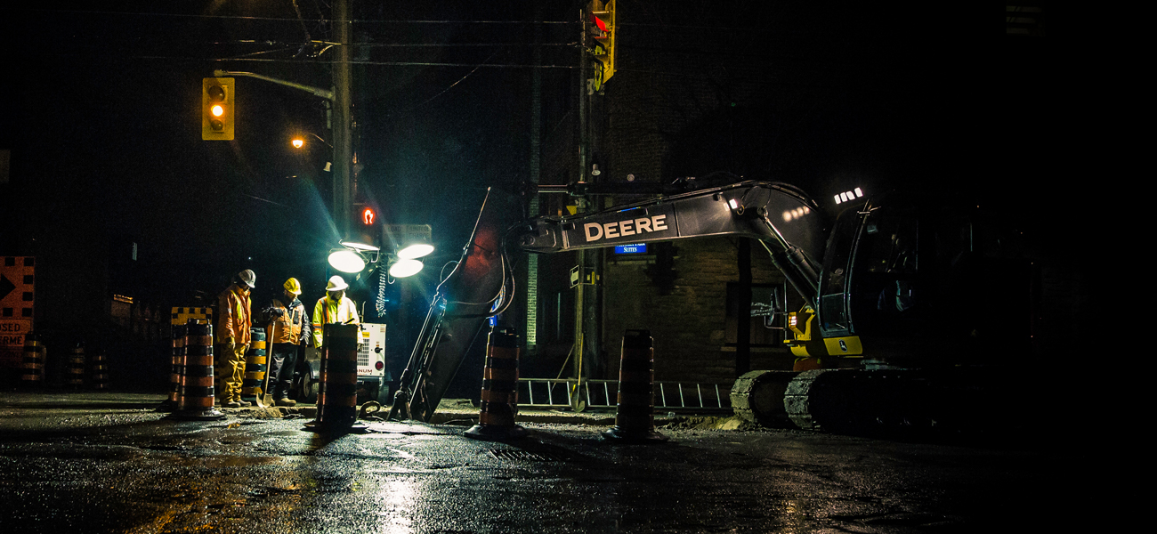 Construction workers repairing road at night